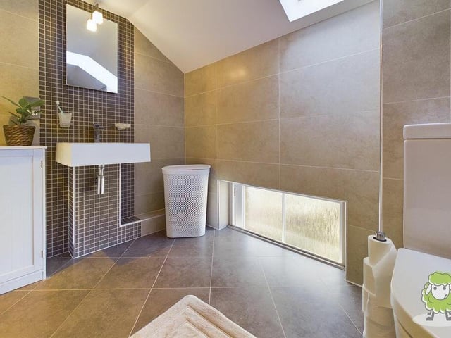 The master bedroom boasts a sleek en suite wet room with shower and wash hand basin.