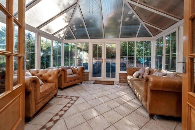 Next to the dining room sits this luxurious conservatory, with its tiled floor and French doors leading out on to a large terrace garden.