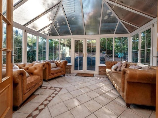 Next to the dining room sits this luxurious conservatory, with its tiled floor and French doors leading out on to a large terrace garden.