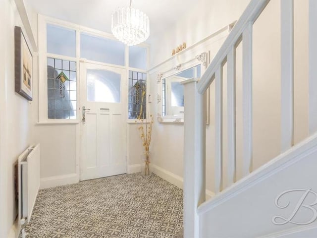 It's time to move upstairs now, so let's pass through the entrance hallway, which has feature windows and a tiled floor.