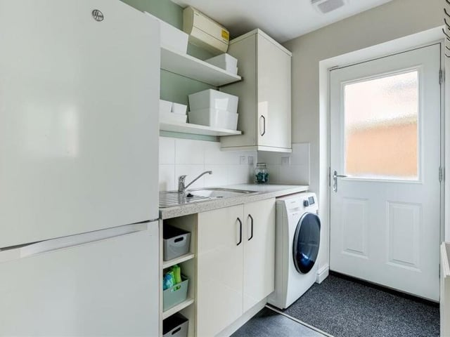 Just off the kitchen diner is this handy utility room, which has space and plumbing for a washing machine, and space for a fridge freezer. There are fitted base and wall units, a worktop and a stainless steel sink with mixer tap and drainer. The door leads out to the side of the house.