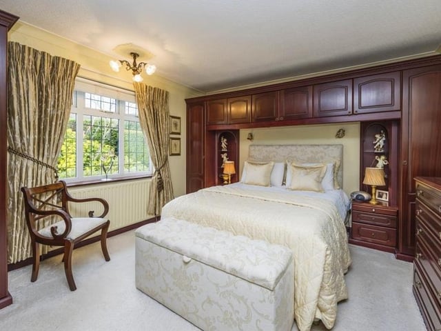 This is a grand-looking bedroom, complete with carpeted floor and fitted furniture.