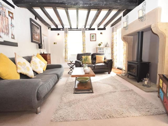 We begin our tour of Maid Marian's Cottage by stepping into the spacious and characterful lounge. The room boasts an exposed, beamed ceiling and a gas log burner, set in its original, handsome sandstone surround, which makes for a picturesque focal point.