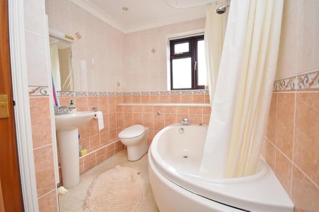 The family bathroom is fitted with a matching suite comprising a panelled bath with mixer shower over, pedestal wash basin and low-level WC. There is also a cupboard housing the hot-water cylinder, while the walls are tiled.