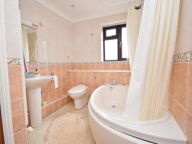 The family bathroom is fitted with a matching suite comprising a panelled bath with mixer shower over, pedestal wash basin and low-level WC. There is also a cupboard housing the hot-water cylinder, while the walls are tiled.