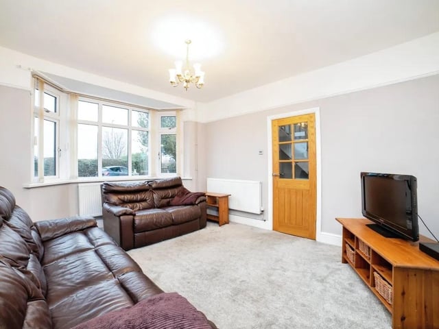 The living room features a lovely bay window and multi fuel burner.