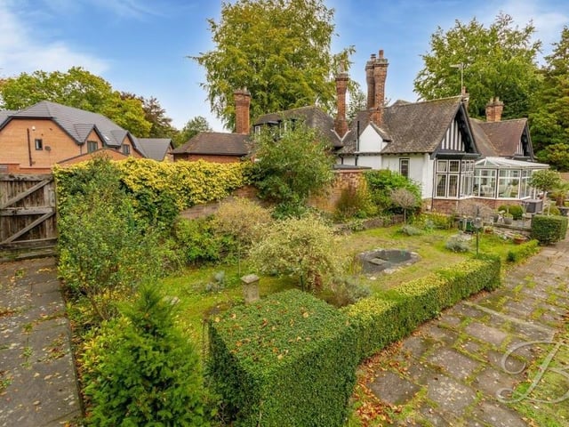 The £795,000 home boasts extensive grounds, with mature trees and a lawn. This photo shows the picturesque back garden.