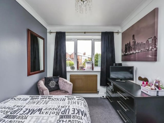 This narrow but stylish bedroom, which has a carpeted floor, offers front-facing views.