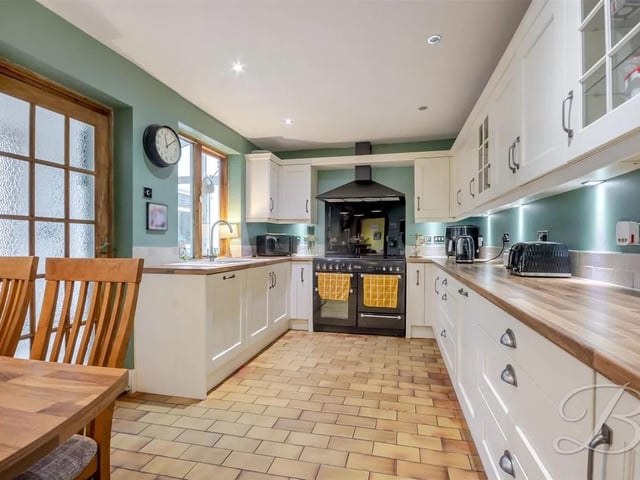 A well-appointed space with abundant storage cupboards and elegant work surfaces, featuring an integrated hand wash basin