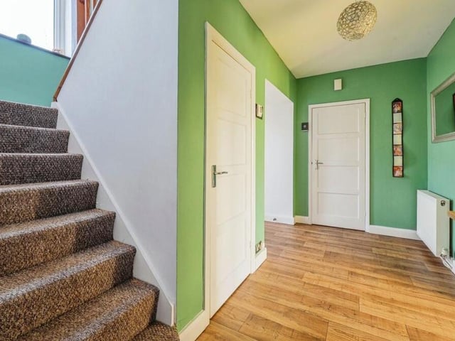 Time to check out the upper floors now, which means passing through the entrance hallway and climbing the stairs.The space has a vinyl floor and an under-stairs storage cupboard.