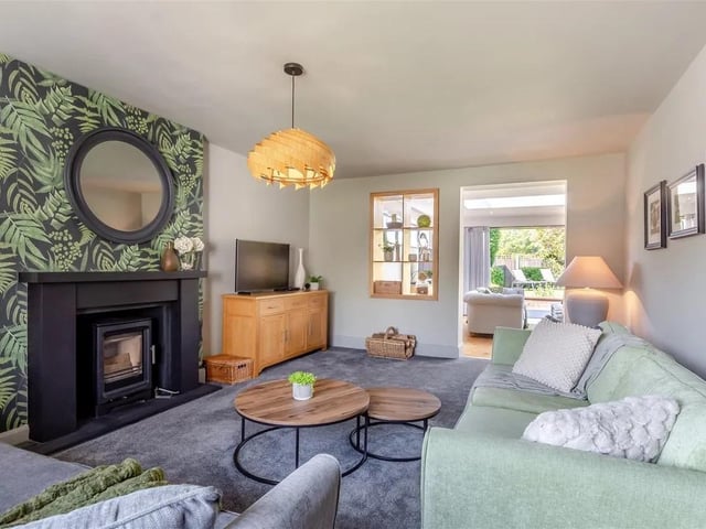 The cosy lounge has a log burner mounted on a slate hearth with composite surround. Radiator, double glazed window to the front elevation and feature oak display shelving