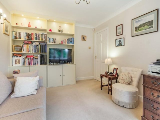 The second bedroom (or sitting room) also features large floor-to-ceiling book-shelves, with four inset spotlights and lower-level base cabinets.