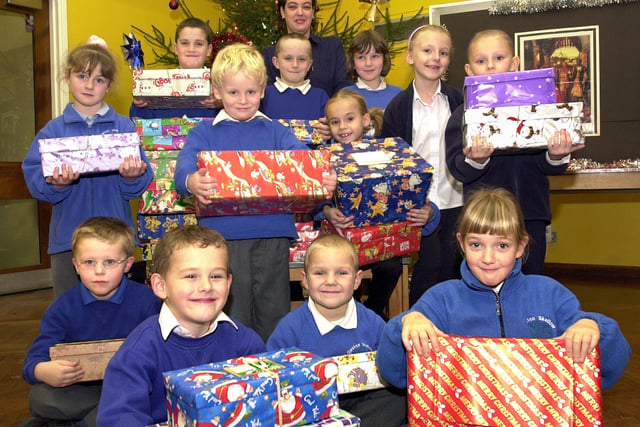 Pupils pictured with some of the shoeboxes that were donated to Operation Christmas Child in 2003. The pupils are, back row,  Jack Boylin, aged nine, Aiden Boylin, aged eight, and Michelle Evans, aged seven; middle row, Charlotte Sanderson, aged five, Jack Graham , aged five, Hannah Sheppard, aged seven, Karina Shawcroft, aged seven, and Chloe Shawcroft, aged six; front row, Brandan Shipman, Tyler Markham, both aged six, Alex Lindley, aged five, and Rebecca McDonald, aged six. Looking on ready to collect the boxes is Dixon Citreon's sales administrator Amanda Hutchinson.