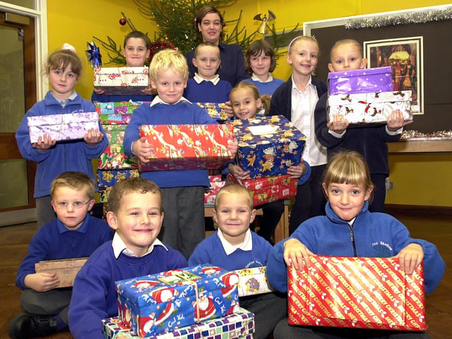 Pupils pictured with some of the shoeboxes that were donated to Operation Christmas Child in 2003. The pupils are, back row,  Jack Boylin, aged nine, Aiden Boylin, aged eight, and Michelle Evans, aged seven; middle row, Charlotte Sanderson, aged five, Jack Graham , aged five, Hannah Sheppard, aged seven, Karina Shawcroft, aged seven, and Chloe Shawcroft, aged six; front row, Brandan Shipman, Tyler Markham, both aged six, Alex Lindley, aged five, and Rebecca McDonald, aged six. Looking on ready to collect the boxes is Dixon Citreon's sales administrator Amanda Hutchinson.