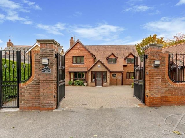 Our final photo of the £650,000 house shows the grand entrance via large, electric gates, which lead to a private driveway, offering off-street parking space, and an attached garage (right).