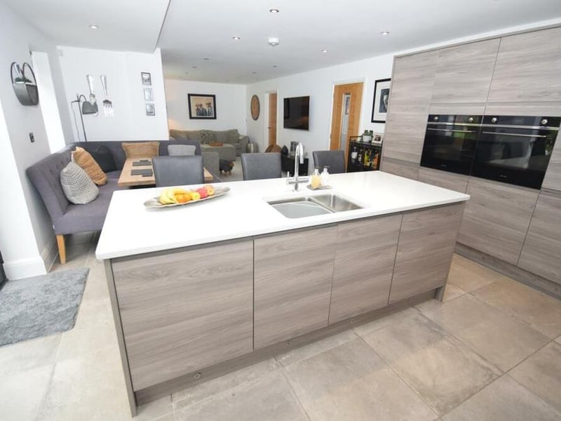 The kitchen boasts high-quality fixtures, including two ovens, a four-ring halogen hob with extractor above, fridge, freezer and dishwasher. It is fitted with bespoke wall and base units, as well as sleek, granite worktops.