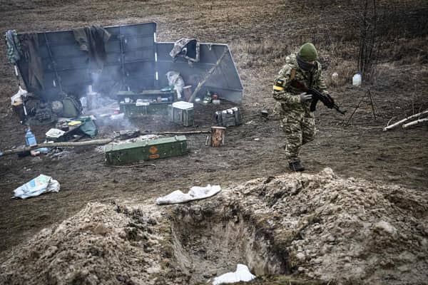 An Ukrainian soldier walks away from a camp fire at a frontline, northeast of Kyiv on March 3, 2022.
