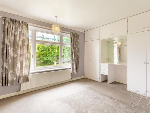 Moving on to the bedrooms now, and here is the first. It's a good size, with fitted wardrobes and a dressing-table area.