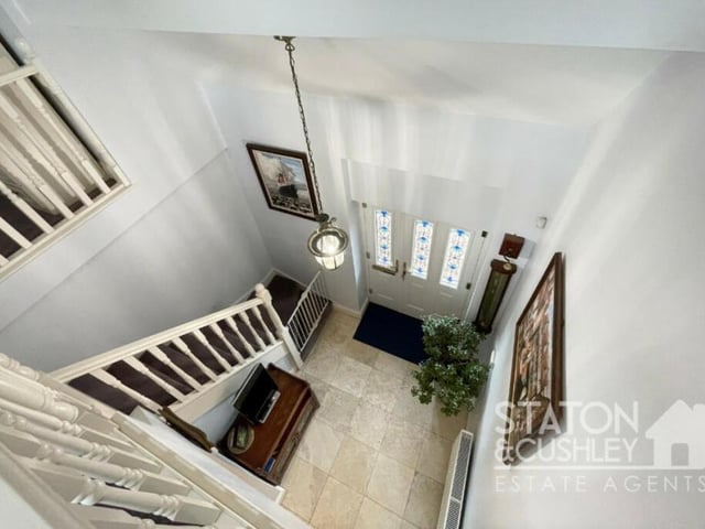 A view of the front door and entrance hall from the open gallery landing on the first floor.