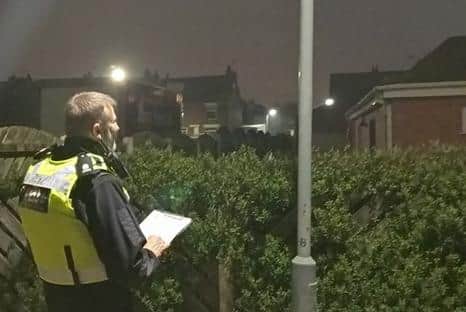 An officer assesses lighting levels.