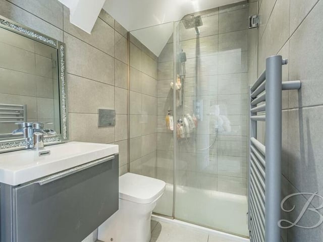 Three of the bedrooms boast en suite facilities. This one is fitted with an enclosed shower, wash hand basin with vanity storage, low-flush WC and heated towel-rail.