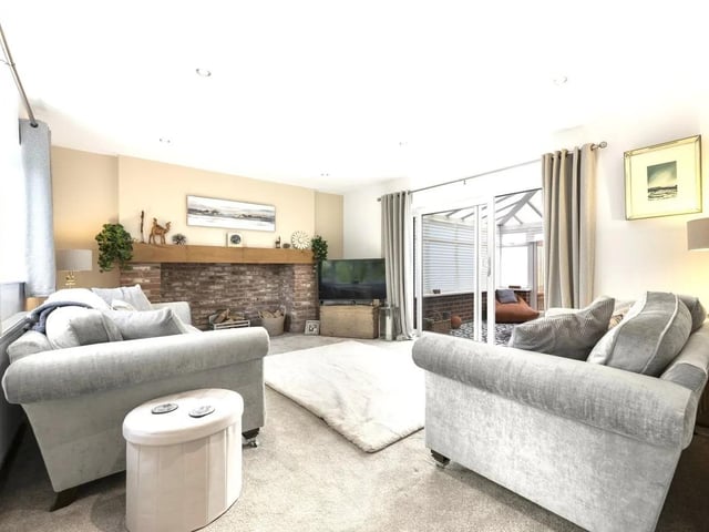 The formal lounge exudes sophistication and provides a quiet retreat. The stand-out feature of the room is an exquisite large fireplace with a traditional exposed brick surround, having a rustic-style wooden mantle beam and smart tiled hearth. A sliding patio door leads into the conservatory.