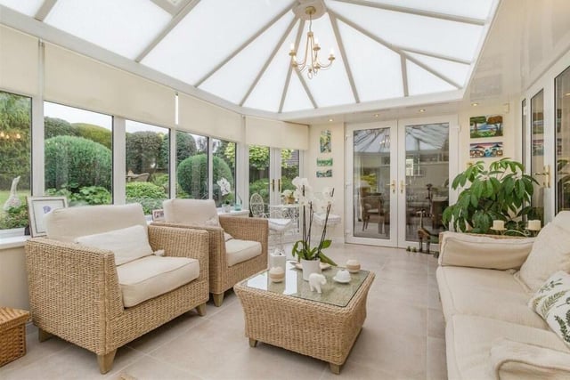 The conservatory at the £450,000 property is airy and spacious, with a roof window and French doors leading into the back garden.