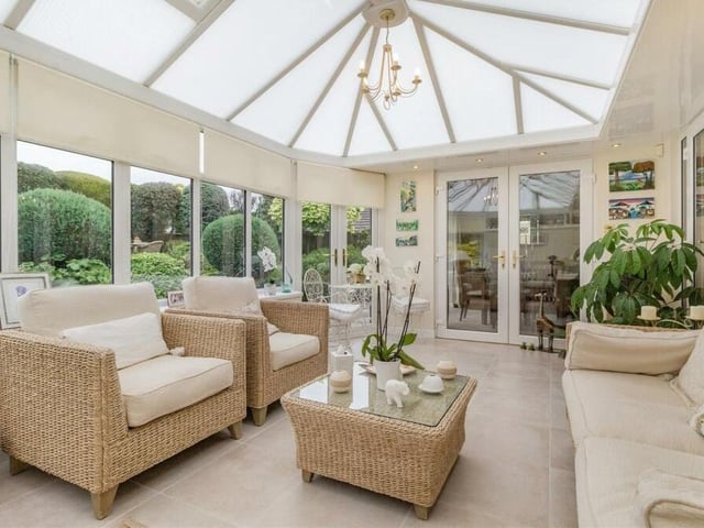 The conservatory at the £450,000 property is airy and spacious, with a roof window and French doors leading into the back garden.