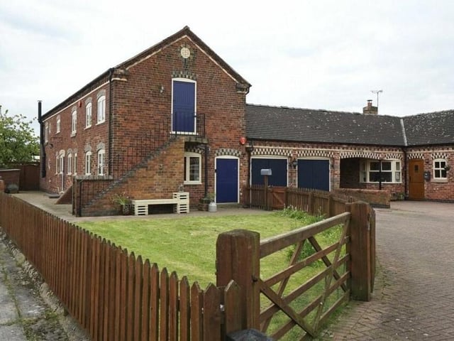 At the front of the £525,000 property is a lawned garden and off-street parking space that leads to a double garage. The garage is currently being used as a workshop and utility room, and houses the property's boiler.