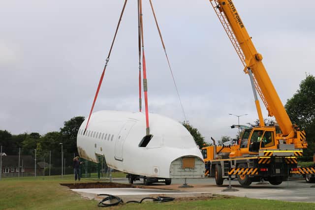 A crane lifts the fuselage of the Airbus A320 into position.