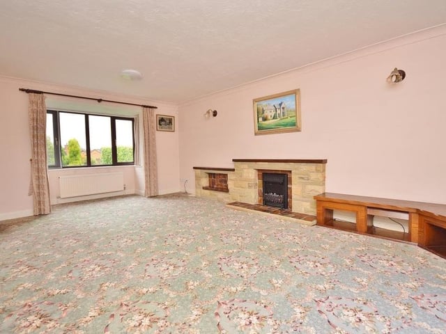 As we begin our tour of the Ravenshead property, let's take a look at the large lounge, which is light and bright thanks to a uPVC patio door at the rear and a uPVC bay window at the front. There is an electric fire with a stone surround.