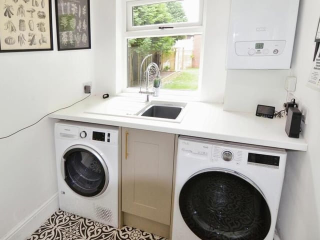 Not far from the kitchen is this convenient utility room, which houses the boiler and has space and plumbing for a washing machine and tumble dryer.
