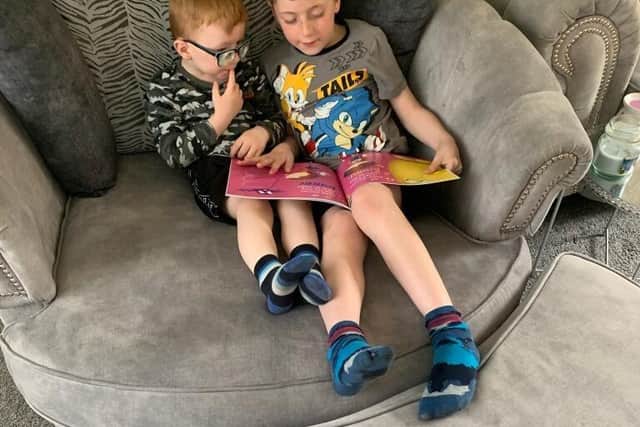 Big brother Logan, reading to little brother Olly. Photo: Sharon Hartshorn