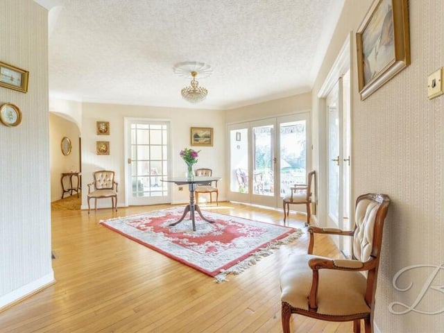 Moving on now to the sun room, which has large windows overlooking the garden and sliding doors leading outside.