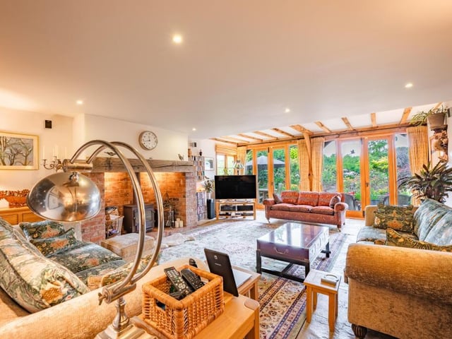 We begin our tour of the £1.15 million house in the large and stylish lounge or living room, where oak doors connect the space to a rose garden outside..