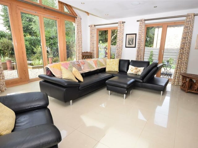 The lounge is radiantly bright, thanks to stunning picture-windows, offering lovely views, and also sets of double doors that lead outside to the tranquil garden