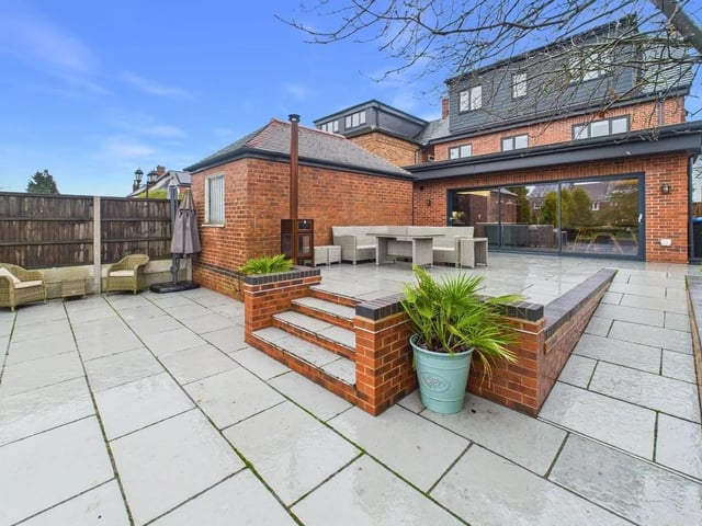 A large paved patio area, easily accessed from the main living space via the sliding doors, is ideal for al fresco dining, summer gatherings, or simply relaxing in the sun.