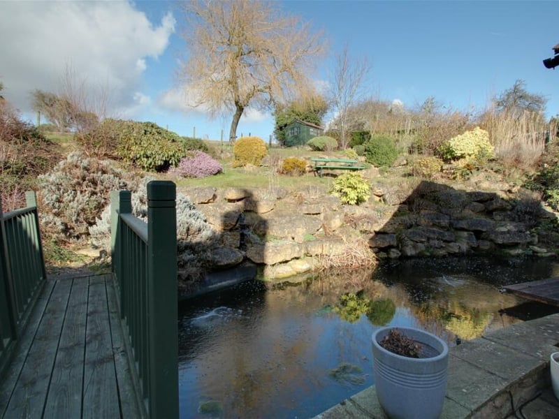 It could be a scene from a tourist guide, showing off one of the UK's pretty rural villages. In fact, it's a scene from WITHIN the plot at High Street, Whitwell as an exquisite bridge leads you over its pond and into the garden.