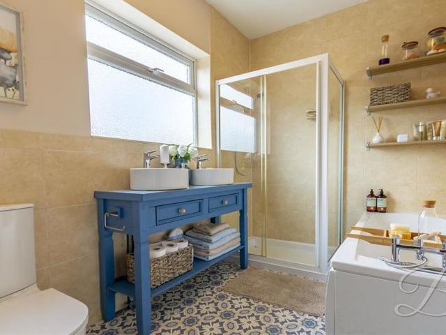 The bathroom at the Budby Avenue bungalow is a bonny space, complete with a fitted bath, walk-in shower cubicle, hand wash basin and low-flush WC. The opaque window faces the back of the property.