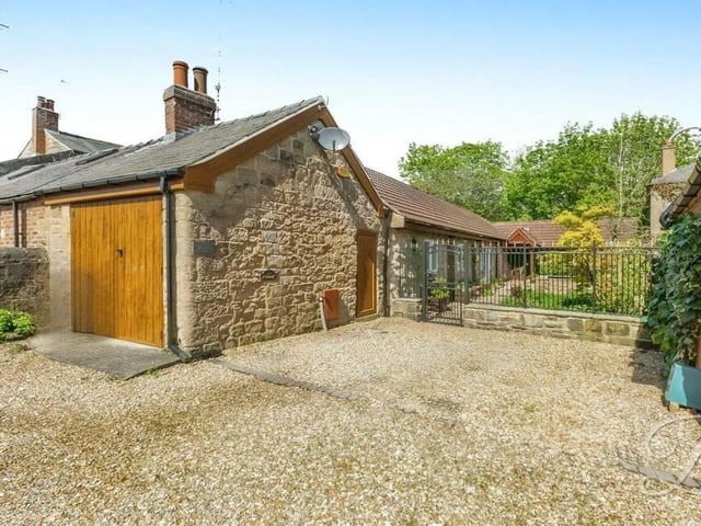 Stepping outside, where a driveway provides off-street parking space and leads to a garage and workshop.