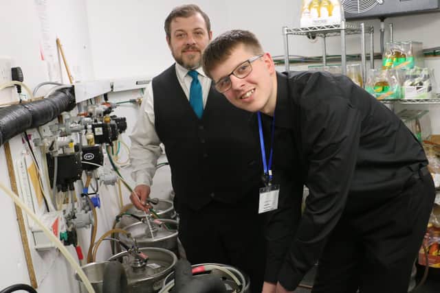 Kieran Peet learns how to change a barrel in the bar with food and beverage team leader Brett Westwood.