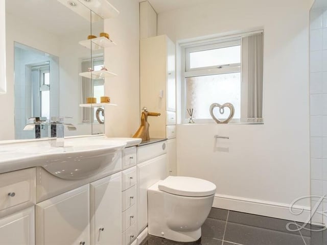 The family bathroom at the £500,000-plus bungalow is fitted with a shower, wash hand basin and low-flush WC. There is also vanity storage, tiled flooring and two windows overlooking the conservatory.