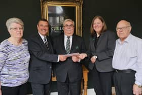 Alan Winfield (centre) receives a retirement gift from Gillotts Funeral Directors.