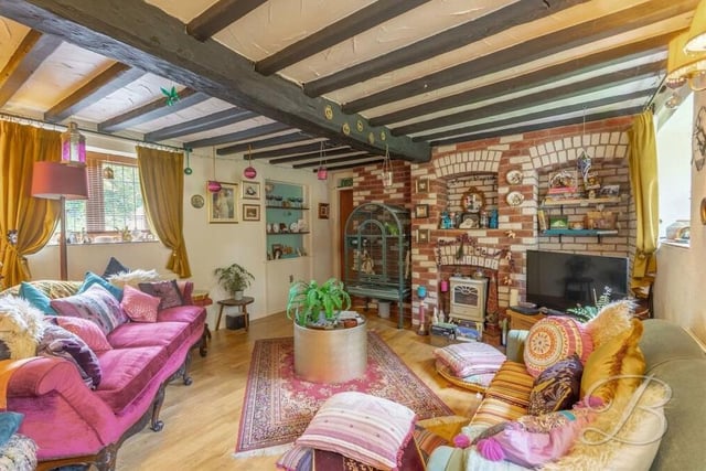 The colourful and characterful living room at the £350,000 property also boasts a feature fireplace.