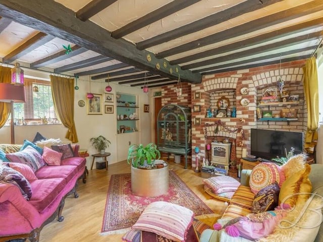 The colourful and characterful living room at the £350,000 property also boasts a feature fireplace.