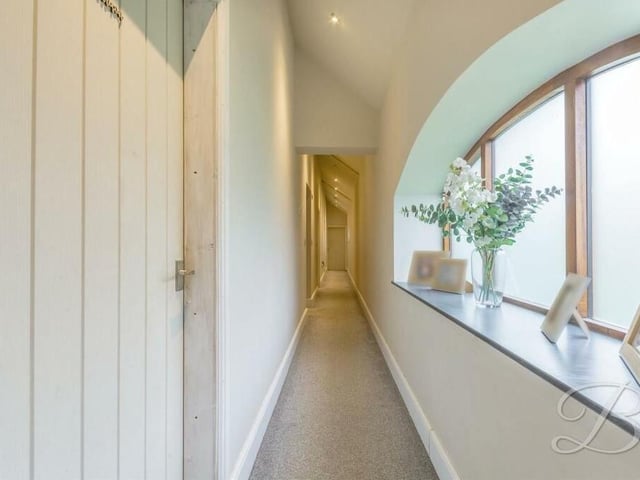 To get to the four bedrooms, let's side down this narrow but characterful hallway, which adds extra charm to the £425,000-plus barn conversion.
