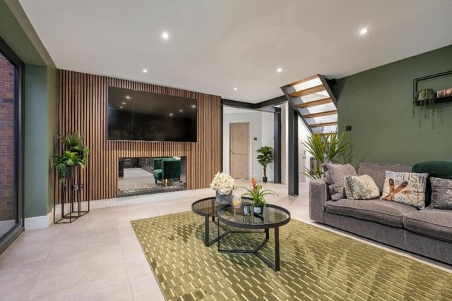 The first of two large reception rooms is this lounge, with a modern feature wall that incorporates a double-side bioethanol living-flame fire with an additional scent option. Recently decorated, the room has a warm and cosy feel.