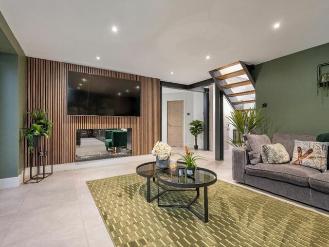 The first of two large reception rooms is this lounge, with a modern feature wall that incorporates a double-side bioethanol living-flame fire with an additional scent option. Recently decorated, the room has a warm and cosy feel.