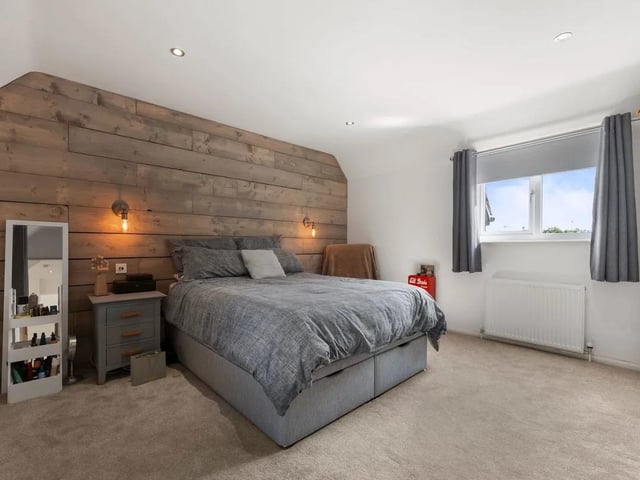 A second spacious double bedroom featuring fabulous contemporary panelled wall detail. The room enjoys dual-aspect uPVC windows to the front and rear, and there is downlighting and a radiator.
