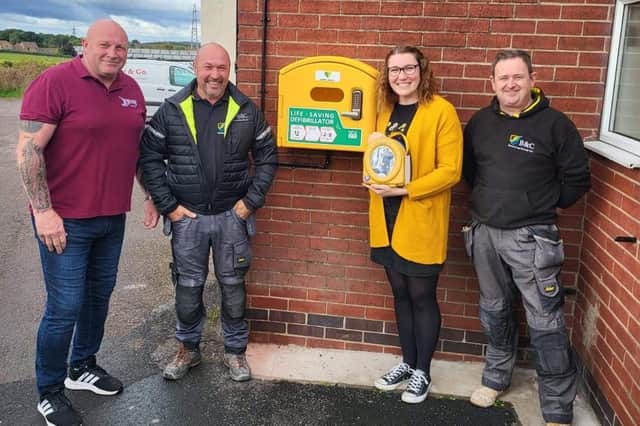 Pub staff and charity volunteers with the new defibrillator at the Cricketers Arms.